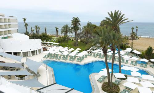 an aerial view of a resort with a swimming pool and the ocean at Imperial Island by Louis Hotels in Yeroskipou