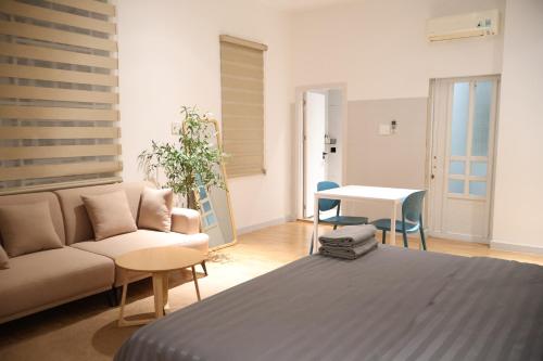 a living room with a bed and a couch and a table at GIA Hotel & Serviced Apartment in Nhơn Trạch