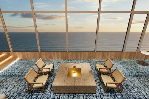 a room with chairs and a table and the ocean at TAOYA Atami in Atami