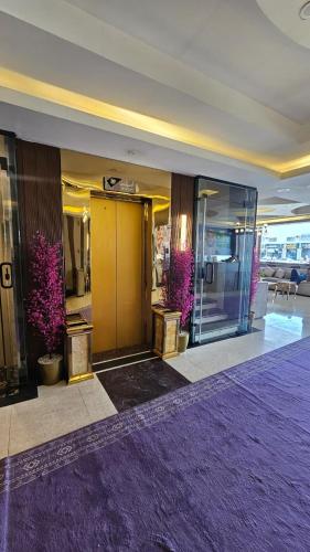 a lobby with a yellow door and some purple plants at اصداء الراحة للشقق المخدومة 3 in Riyadh