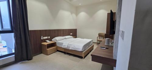a bedroom with a bed and a desk and a television at ANTARA STAY in Coimbatore