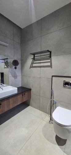 a bathroom with a white toilet and a sink at ANTARA STAY in Coimbatore