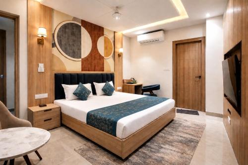 a hotel room with a bed and a table and a television at Hotel Velvet The Ultimate in Prayagraj