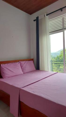 a bedroom with a purple bed with a window at Summer Dream in Badulla