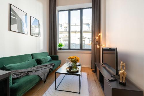 a living room with a green couch and a table at Old Town Loft in Tartu