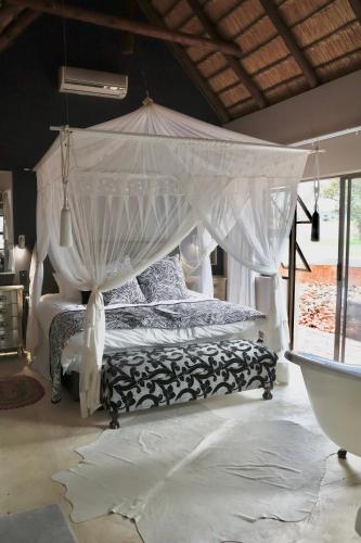 a bedroom with a bed with a canopy at Bushveld Venue in Mabula