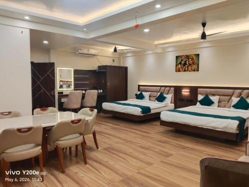 a hotel room with two beds and a table and chairs at Hotel Navil Exotica in Chicalim