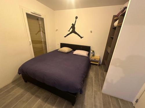 a bedroom with a bed with a jumping man on the wall at Appartement Perpignan in Perpignan