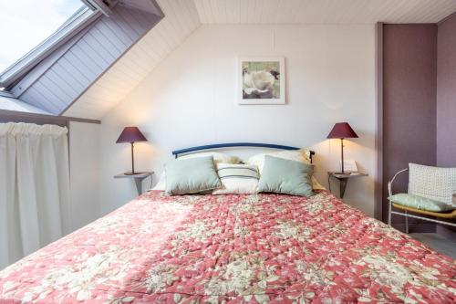a bedroom with a large bed with a floral bedspread at Ty Annick chambres d'hôtes in Névez