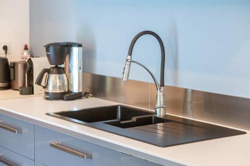 a kitchen sink with a faucet on a counter at La Longère du Salou in Landrévarzec