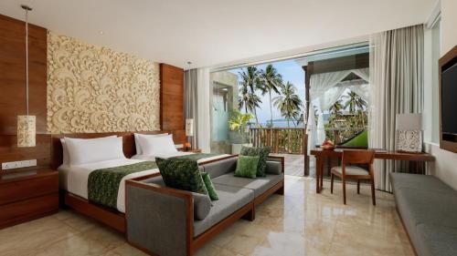 a hotel room with a bed and a desk at Candi Beach Resort & Spa in Candidasa