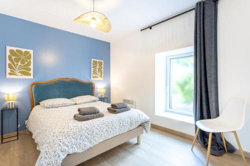 a bedroom with a bed with blue walls and a window at La Longère du Salou in Landrévarzec