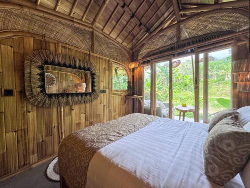 a bedroom with a large bed in a room with windows at Sweet Escape - Boutique Hotel in Sidemen