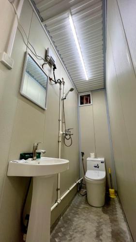 a bathroom with a sink and a toilet at Crossa Inn in Siquijor