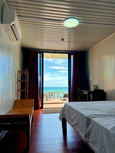 a bedroom with a bed and a view of the beach at Crossa Inn in Siquijor