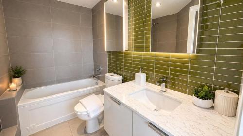 a bathroom with a sink and a toilet and a tub at Pacific Pearl in Vancouver