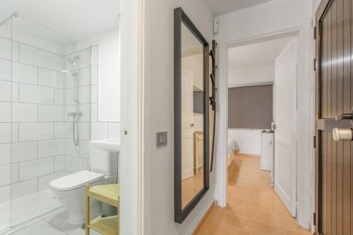 a bathroom with a toilet and a mirror at Oasis Duna _ Casa Mate Pool in Corralejo