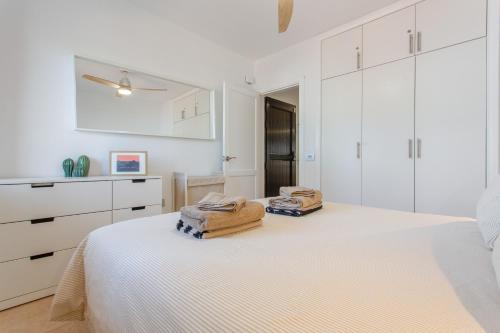 a white bedroom with a bed and white cabinets at Oasis Duna _ Casa Mate Pool in Corralejo