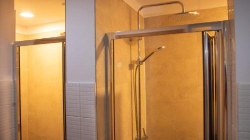 a shower with a glass door in a bathroom at Onefam Clerigos in Porto