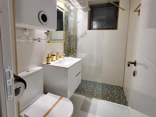 a white bathroom with a toilet and a sink at Apartament Benicarlo2 in Brad