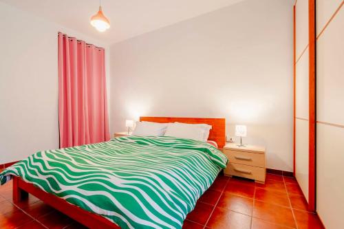 a bedroom with a bed with a green and white blanket at Empoli, intero alloggio vicino Firenze in Empoli