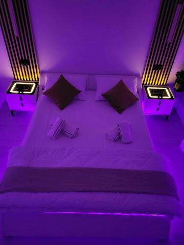 a purple bedroom with a large bed with two night stands at Apartament Benicarlo2 in Brad