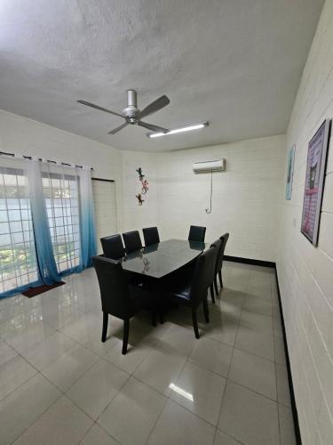 a dining room with a table and chairs and a ceiling fan at Villa Sapphire by Blue Robin - Private Taiping Villa 20pax River & Waterfall in Taiping