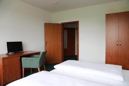 a bedroom with a bed and a desk with a computer at Sporthotel Hostivice in Hostivice