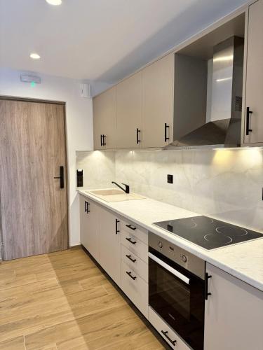 a kitchen with white cabinets and a stove top oven at Celene Luxury Plakias in Plakias