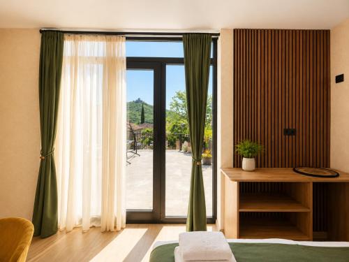 ein Schlafzimmer mit einer Glasschiebetür zur Terrasse in der Unterkunft Hotel Prime in Mzcheta
