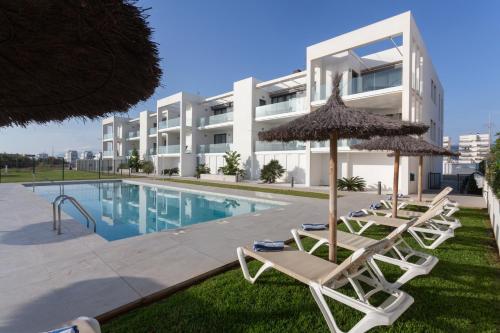 a group of chairs and umbrellas next to a swimming pool at Oliva Suites in Oliva