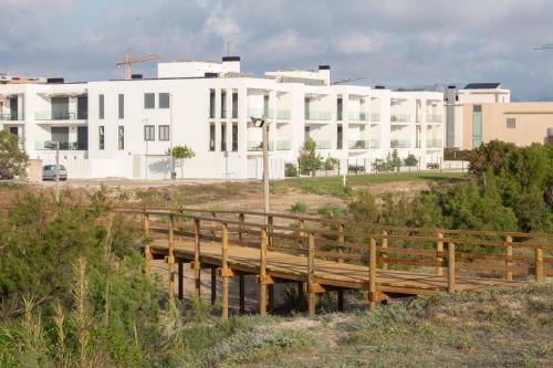 a wooden bridge in front of a white building at Oliva Suites in Oliva