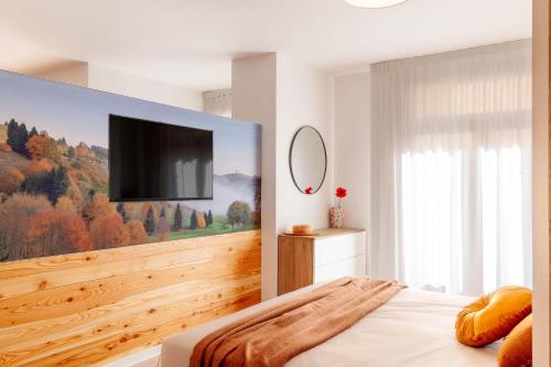 a bedroom with a flat screen tv on a wall at Alle Porte in Vittorio Veneto