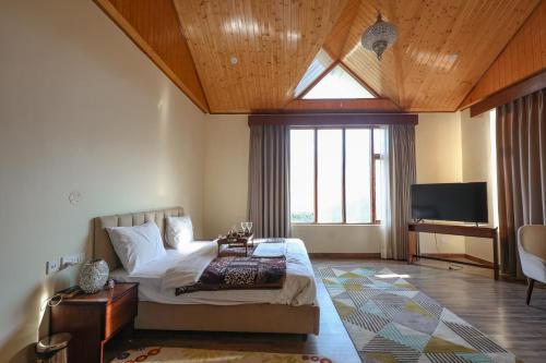 a bedroom with a bed and a large window at Dancing Deer Chalet in Kūfrī