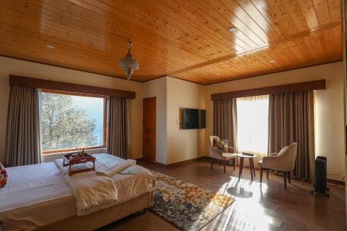 a bedroom with a large bed and a large window at Dancing Deer Chalet in Kūfrī