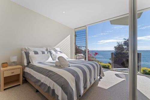 a bedroom with a bed with a view of the ocean at Mirage 1 24 Gloucester Street in Nelson Bay