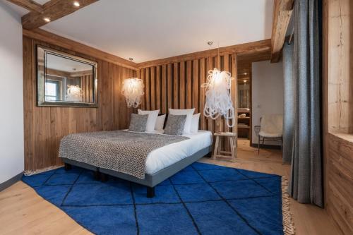 a bedroom with a bed and a blue rug at Chalet Face - LES CHALETS COVAREL in Val-d'Isère