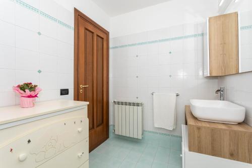 a white bathroom with a sink and a toilet at Il Vulcano di Milo in Milo