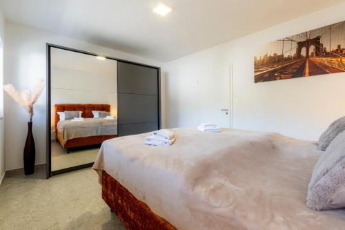 a bedroom with a large bed and a large mirror at Luxury Family Apartment with Terrace FRIGO in Maribor