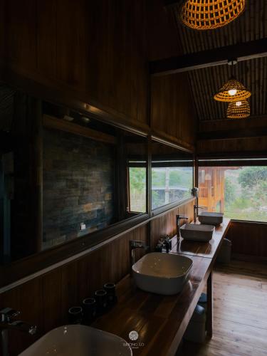 a bathroom with two sinks and two mirrors at Mường Lò Retreat Nghia Lo in Yên Bái