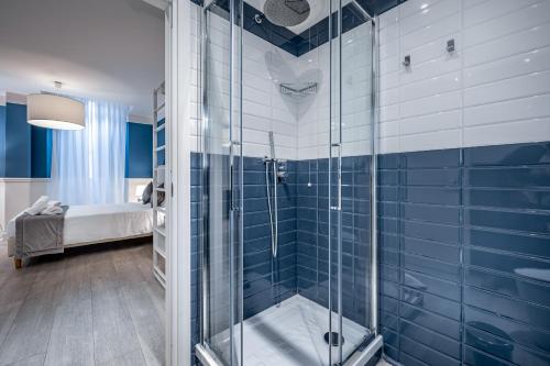 a bathroom with a shower with blue tiles at Garibaldi Luxury apartments in Prato