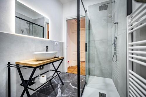 a bathroom with a sink and a glass shower at Five Suites Mantellate 9 in Florence