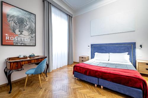 a bedroom with a bed and a desk at Five Suites Mantellate 9 in Florence