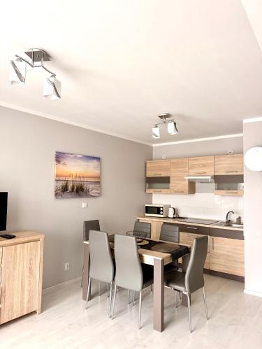 a kitchen and dining room with a table and chairs at Apartament Perełka in Darłowo