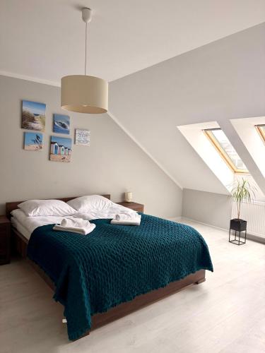 a bedroom with a bed with a green blanket at Apartament Perełka in Darłowo
