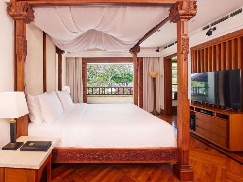 a bedroom with a large bed and a television at Nusa Dua Beach Hotel and Spa - Handwritten Collection in Nusa Dua