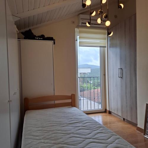 a bedroom with a bed and a large window at SUNTIME apartament 5 in Kotor
