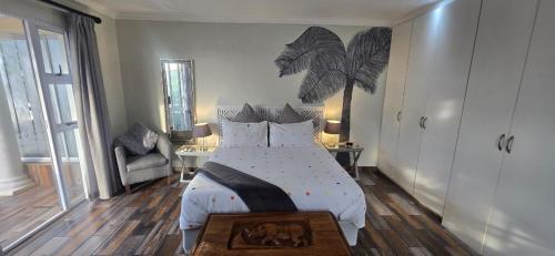 a bedroom with a large bed and a chair at 54 on Asteria 2 in Amanzimtoti