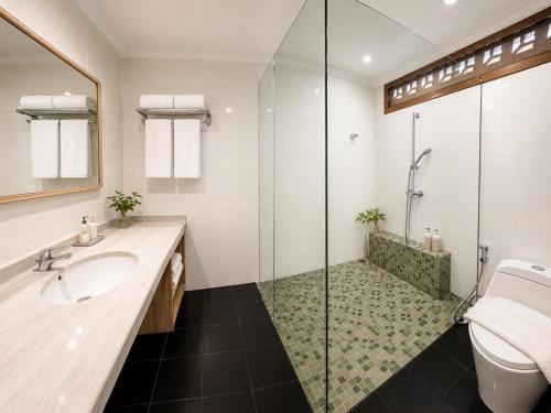 a bathroom with a shower and a sink and a toilet at Radha Bali Hotel in Kuta