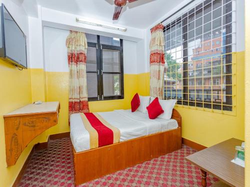 a small bedroom with a bed and a window at Tokyo Hotel in Kathmandu
